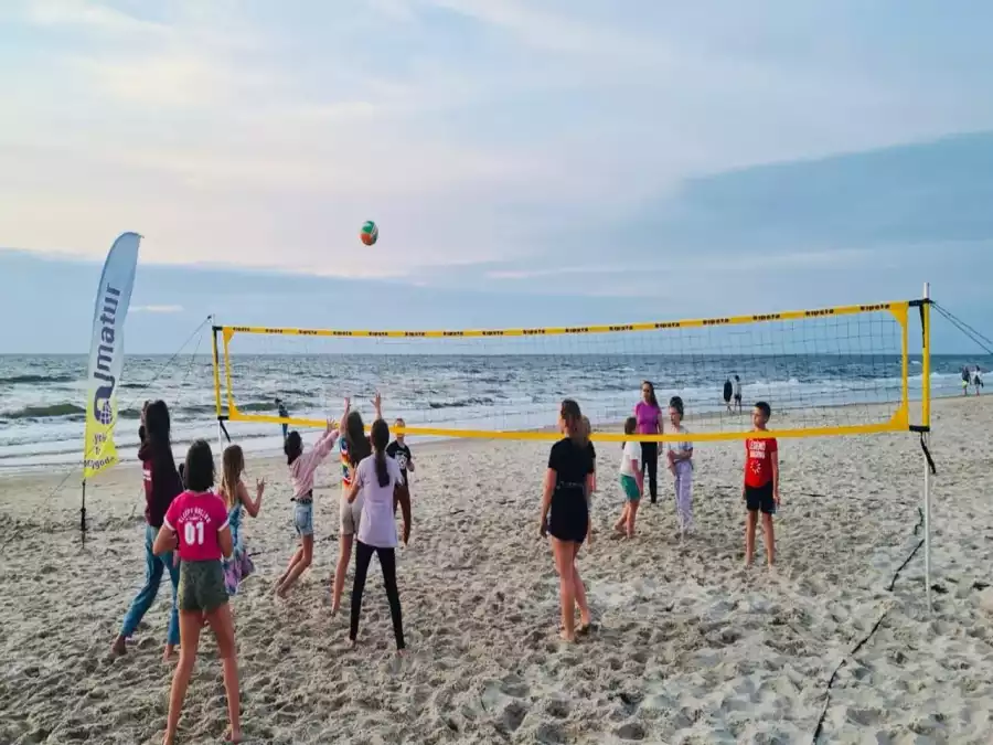 uczestnicy obozy letniego grają w siatkówkę plażową