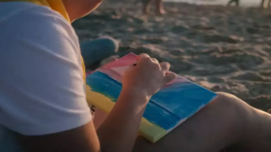 dziewczynka rysuje na plaży