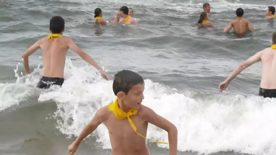 uczestnicy obozu nad morzem bawią się wśród fal