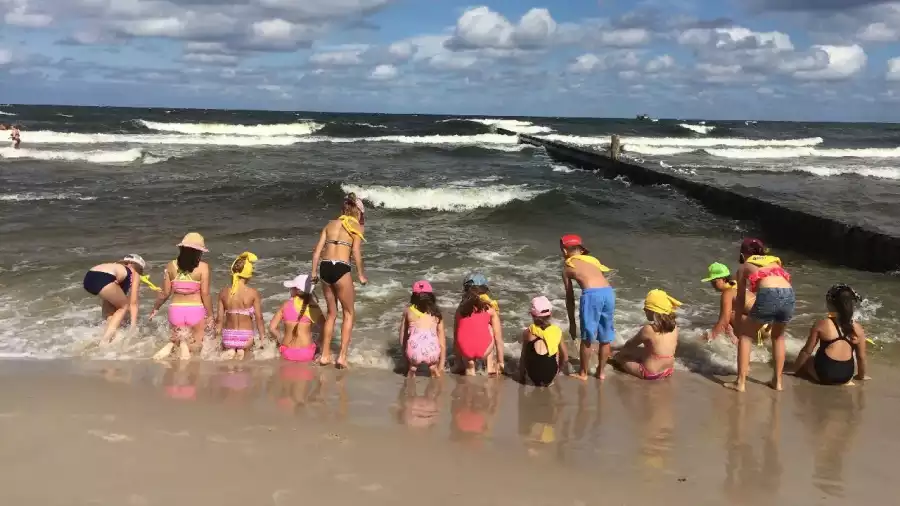 dzieci bawią się przy falochronie