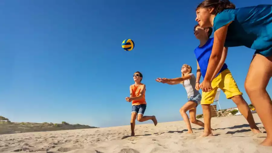 dzieci grają w siatkówkę plażową