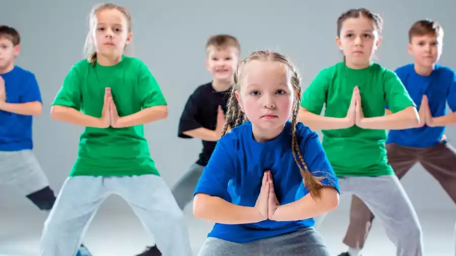 grupa dziecięcych tancerzy pozuje w sali tanecznej